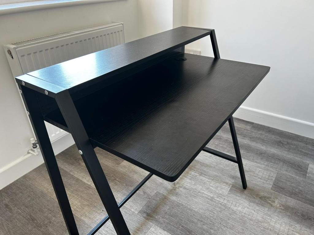 Assembled black flat-pack office desk built by a handyman