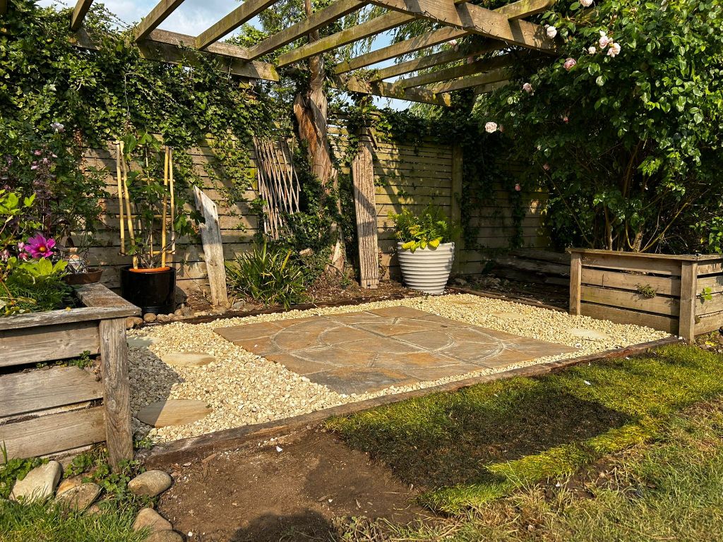 Freshly laid garden patio and lawn with greenhouse installed by handyman