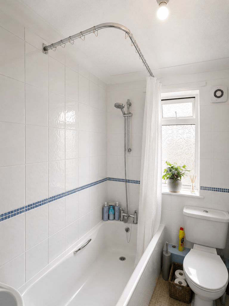 Tiled bathroom with shower over bath fitted by a handyman